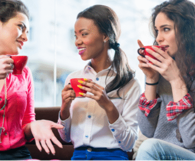 Three women in their 30s and 40s talking over coffee, supporting each other during life transitions like perimenopause."