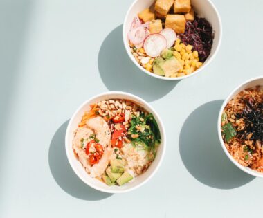 overhead shot of poke bowls on a blue surface